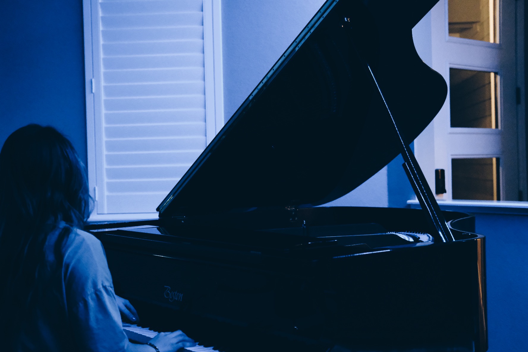 A girl playing piano with a blue background